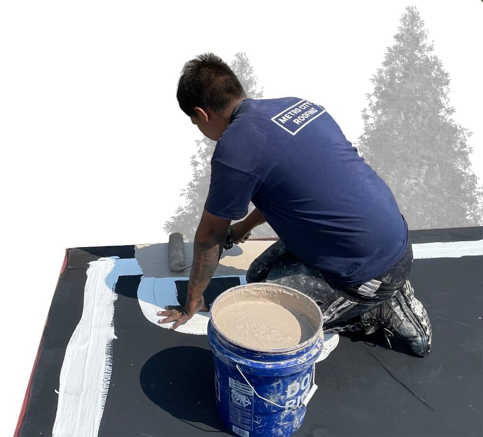 Metro City Roofing crew in a blue shirt applying a silicone coating to a black TPO roof in Denver, CO